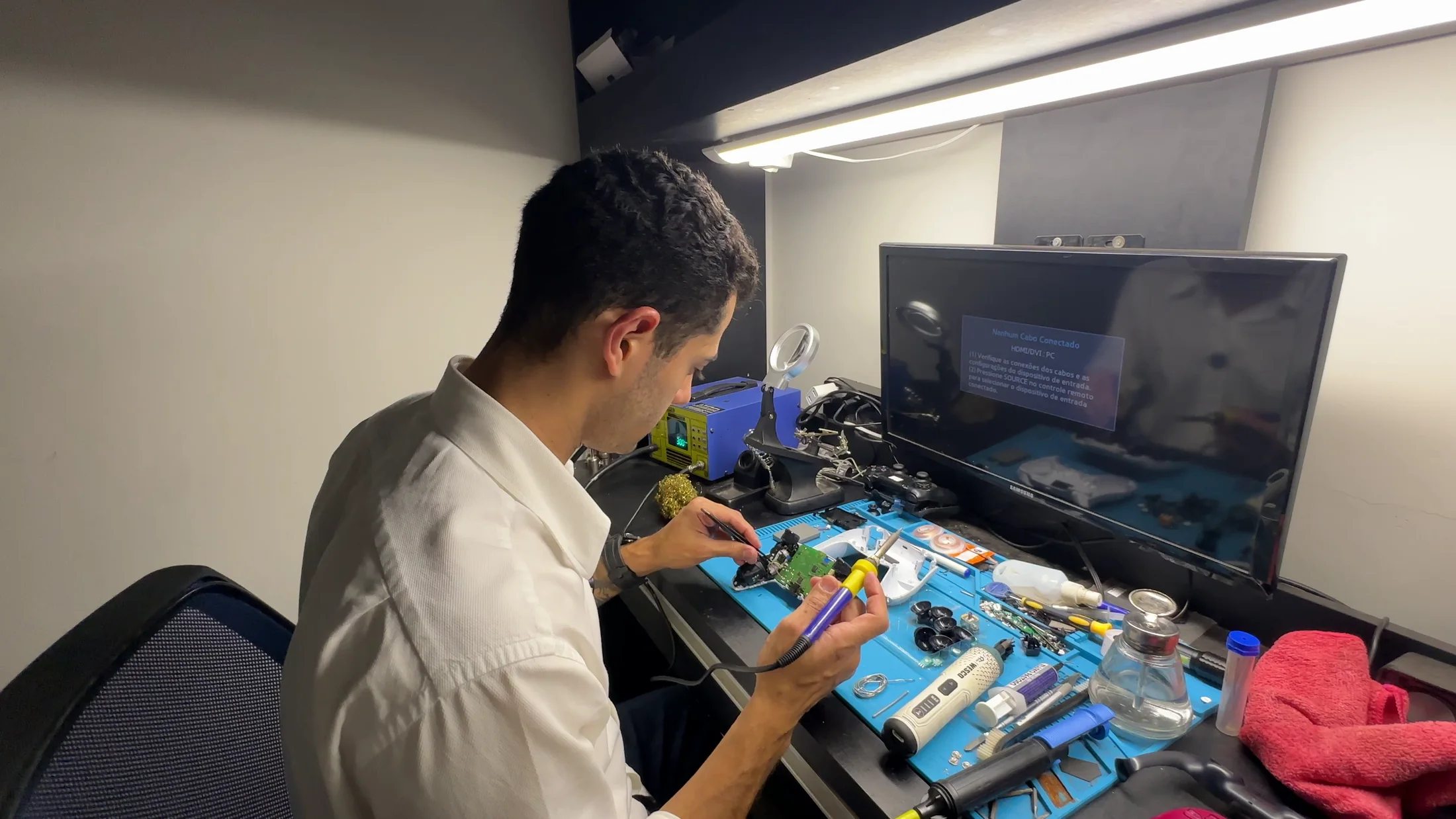 Técnico da Retro Gamers reparando uma placa de controle