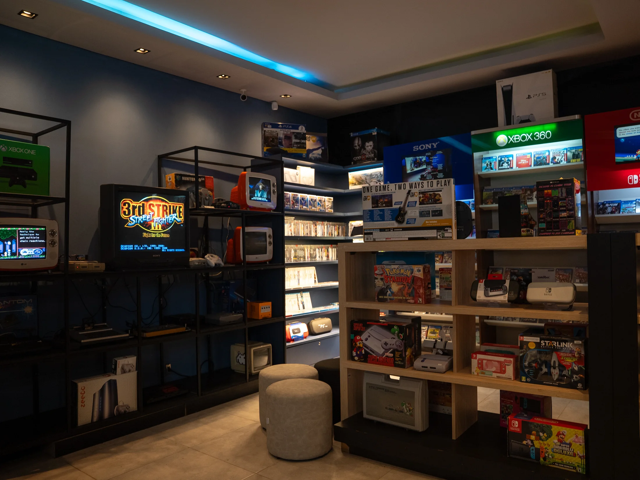 Interior da Retro Gamers com consoles, jogos e iluminação azul